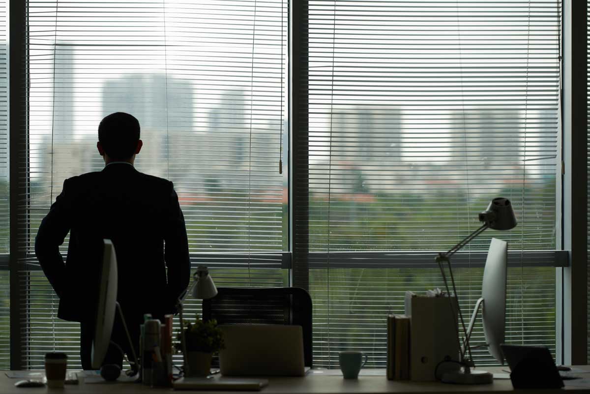 executive looking out office window